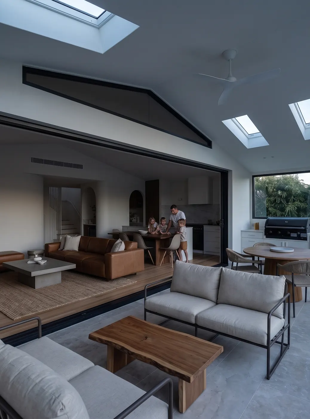 A living room opening onto a covered alfresco, facing south, flat and grey under an overcast sky